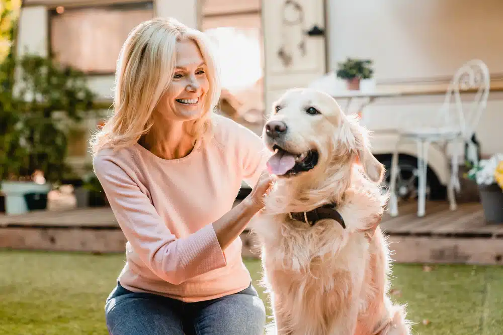 Woman looking after her golden retriever. Statistics on insurance shows how different generations insure their pets