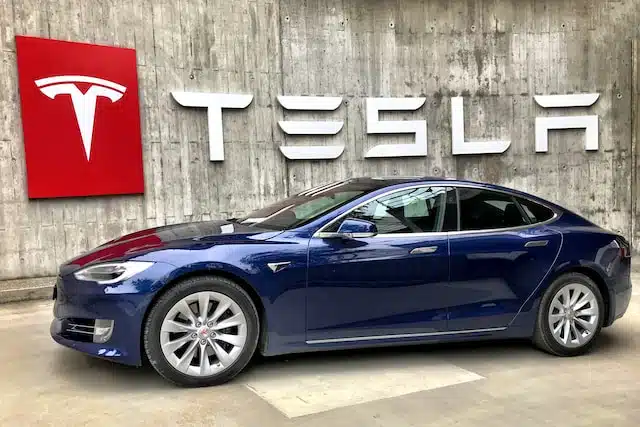 This image shows a Tesla in front of a branded building. the owner may be shopping for insurance for a tesla.