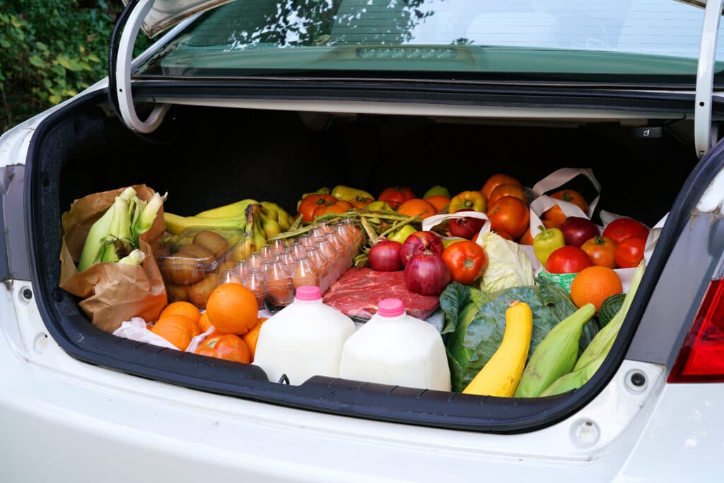 A car boot overloaded with groceries is in dire need of car storage solutions.