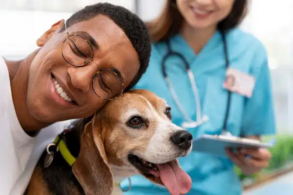 A man, vet, and dog - perhaps thinking about  an insurance comparison