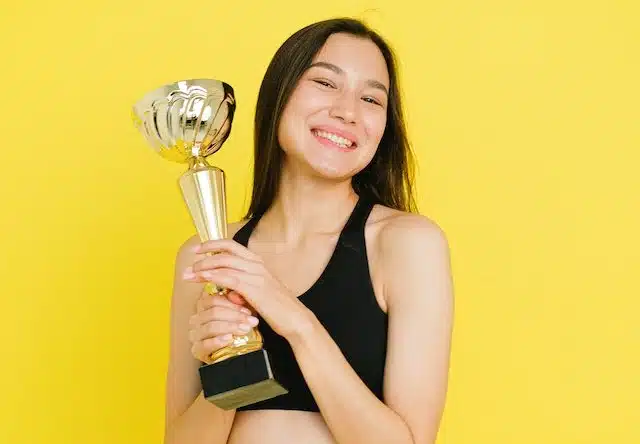 A woman holds a trophy to represent her choice in getting a award winning car insurance from PD Insurance