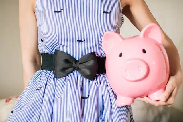 A woman holds a piggy bank to store savings