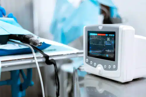 An ecg machine on a table in a hospital. The dog's tail wagging nearby, oblivious to the stone it just ate.