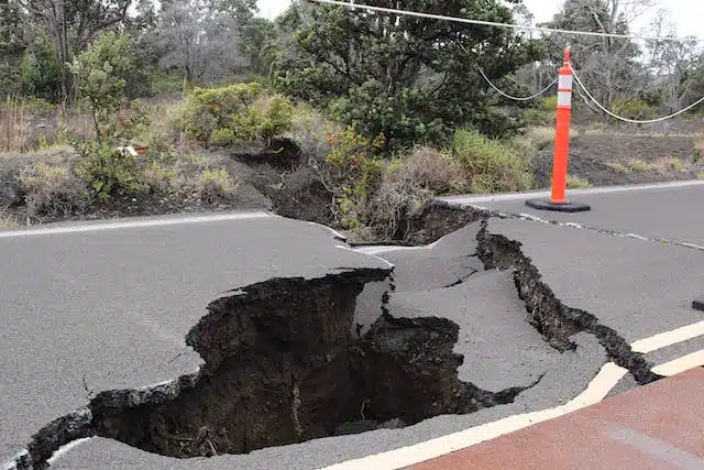 A road with a hole in the middle of it, potentially triggering a force majeure clause in car insurance.