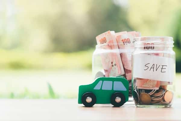 A jar filled with money and a toy car, representing affordable car insurance options.