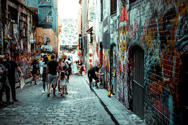 People walking down a narrow Melbourne alley covered in graffiti during the start of an Easter road trip before setting out on the Great Ocean Road. 