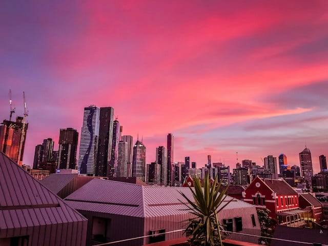 A pink sky over Melbourne city skyline at sunset, a perfect starting point for an Easter road trip.