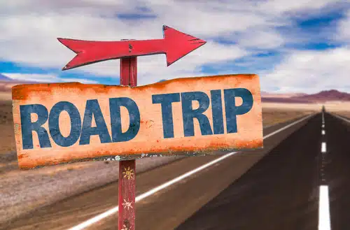 A sign with "Road Trip" and a bold red arrow beckons travelers.