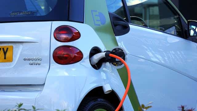 A smart car is plugged into an electric charger