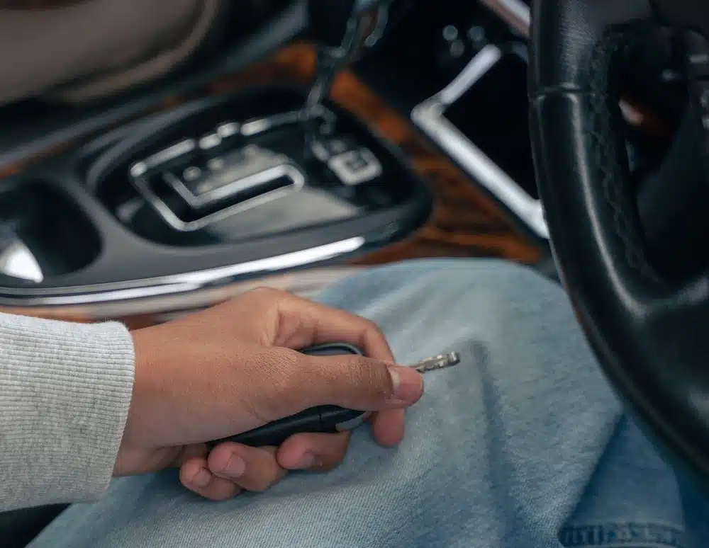 A person trying to start a car with a stiff brake.