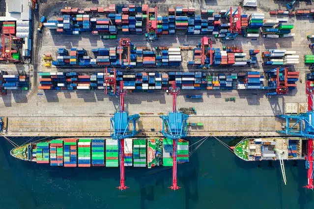 An aerial view of a container ship docked at a port carrying pet food that needs to follow labelling regulations in Australia