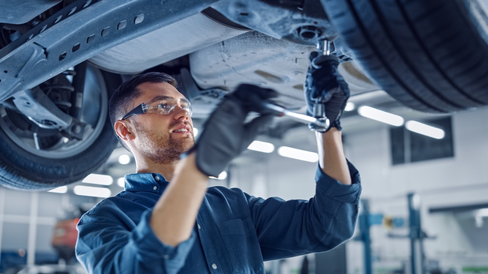 A mechanic performing a major car service in a garage.