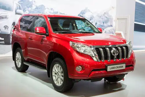 A red Toyota Land Cruiser displayed at an auto show is among the best second-hand cars in Australia.