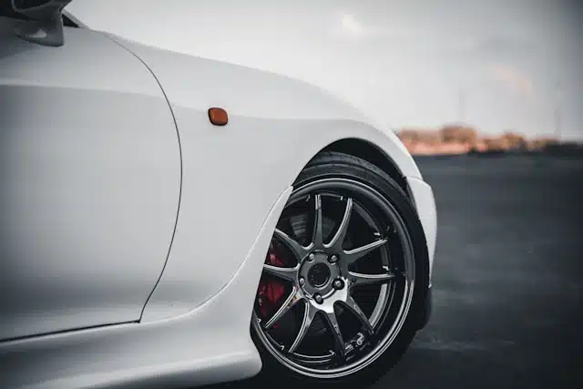 Close-up of a white sports car's rear tire and fender, important for demonstrating detailed wheel alignment to stop tyre wear